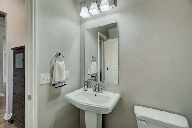 bathroom with sink, toilet, and wood-type flooring