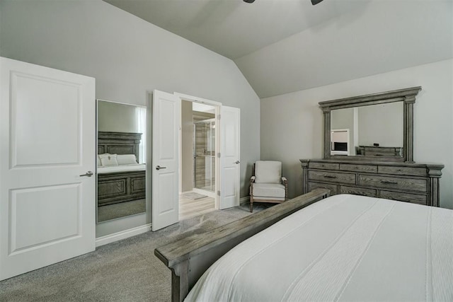 bedroom featuring lofted ceiling, light colored carpet, ceiling fan, and ensuite bath