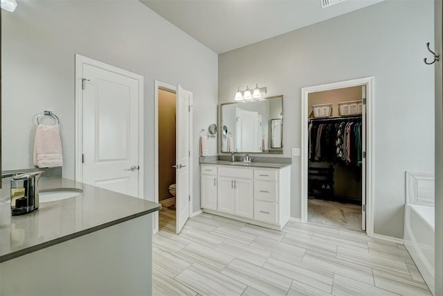 bathroom with a tub, toilet, and vanity