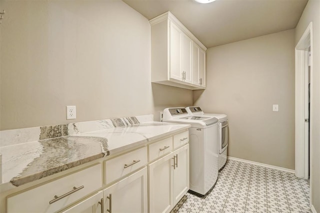 washroom featuring separate washer and dryer and cabinets