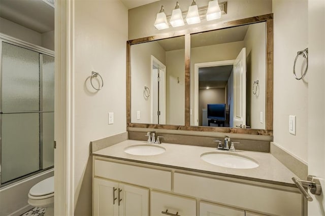 full bathroom featuring toilet, vanity, and enclosed tub / shower combo