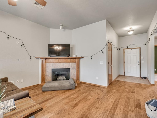 unfurnished living room featuring light wood-style flooring, a fireplace, visible vents, and baseboards