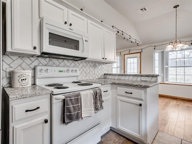 kitchen with a peninsula, white appliances, visible vents, and white cabinets