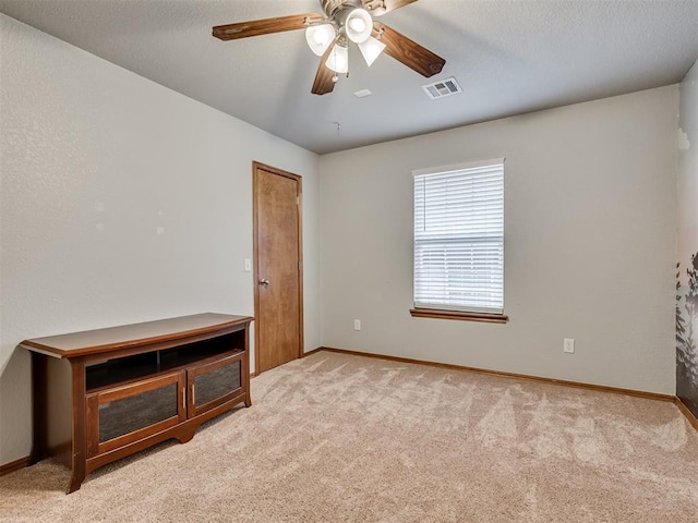 unfurnished room featuring carpet, visible vents, ceiling fan, and baseboards