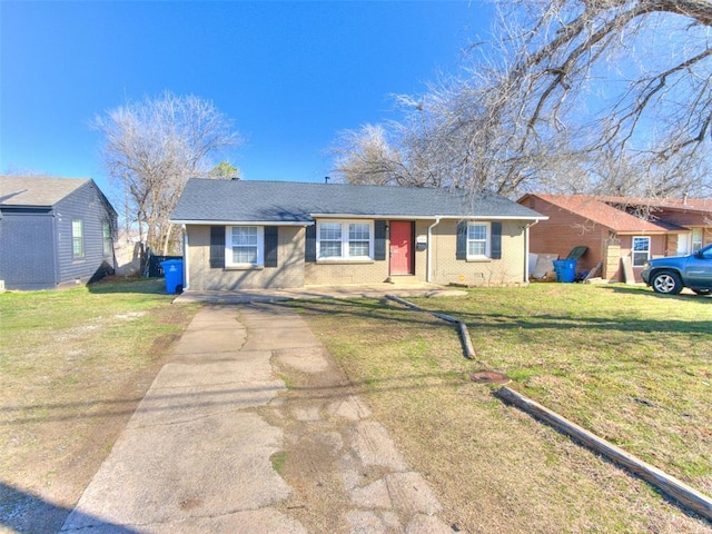 ranch-style home with brick siding, concrete driveway, a front lawn, and roof with shingles