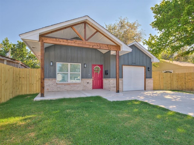 view of front of property featuring brick siding, driveway, an attached garage, and fence