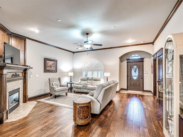 living room with a fireplace, ceiling fan, crown molding, and dark hardwood / wood-style floors