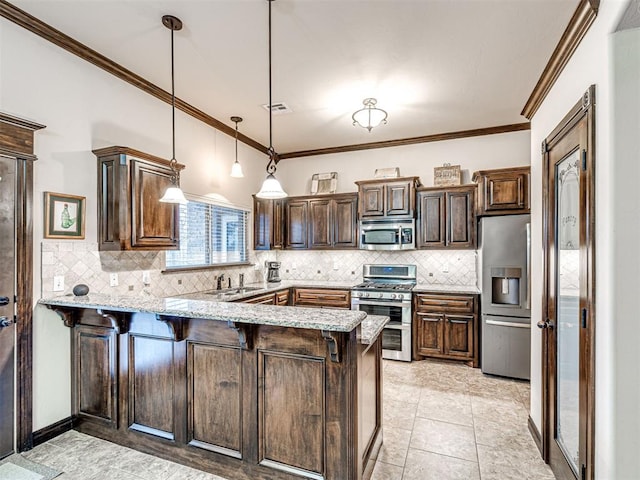 kitchen featuring appliances with stainless steel finishes, a breakfast bar, kitchen peninsula, hanging light fixtures, and tasteful backsplash