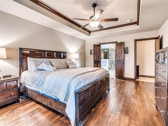 bedroom with hardwood / wood-style flooring, ornamental molding, and a raised ceiling