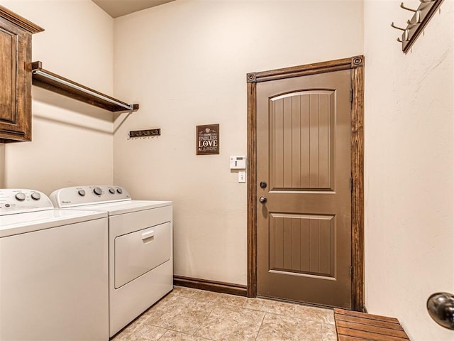 clothes washing area with cabinets and washing machine and clothes dryer