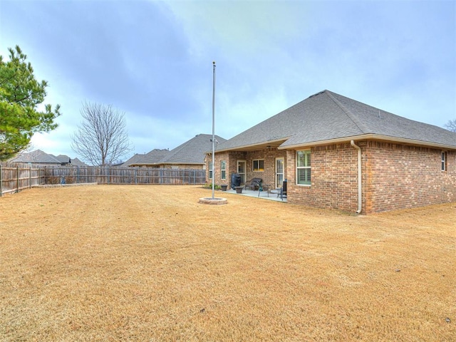 rear view of property featuring a patio area and a lawn