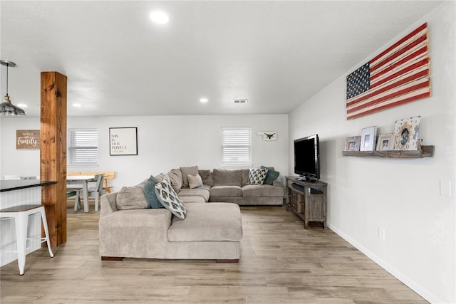 living room featuring recessed lighting, visible vents, baseboards, and wood finished floors