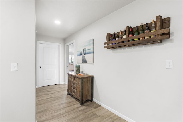 hall with light wood finished floors and baseboards