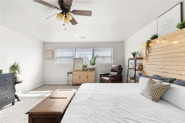 carpeted bedroom featuring a ceiling fan, visible vents, and baseboards