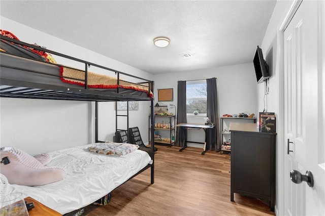 bedroom featuring a textured ceiling and wood finished floors