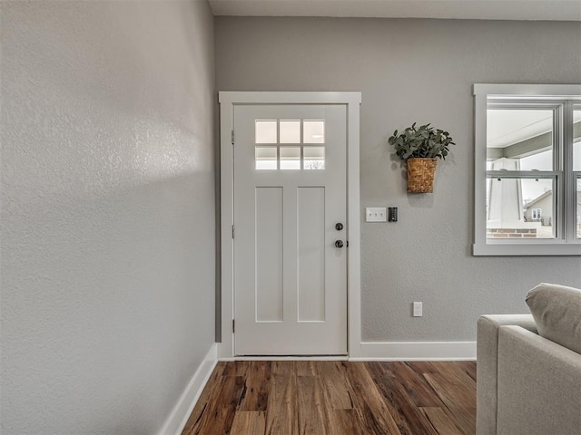 foyer featuring dark wood finished floors and baseboards