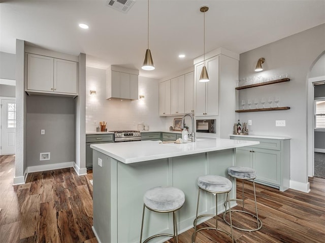 kitchen featuring light countertops, stainless steel range with gas cooktop, open shelves, and visible vents