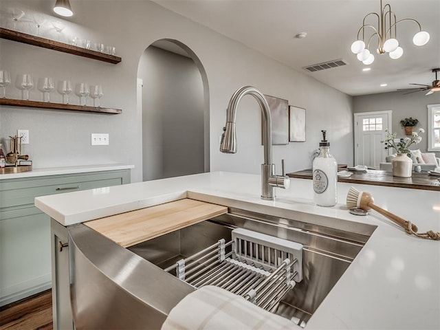 interior space featuring arched walkways, light countertops, hanging light fixtures, and visible vents