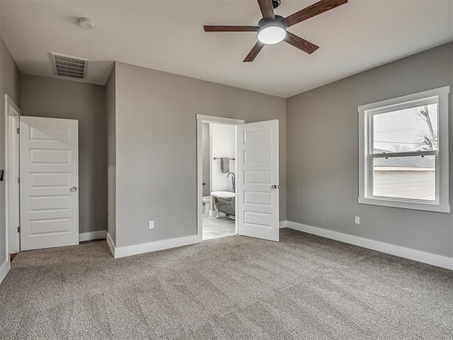 unfurnished bedroom with light colored carpet, visible vents, baseboards, and ensuite bathroom