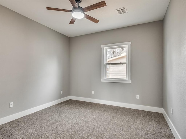 carpeted empty room featuring visible vents, a ceiling fan, and baseboards