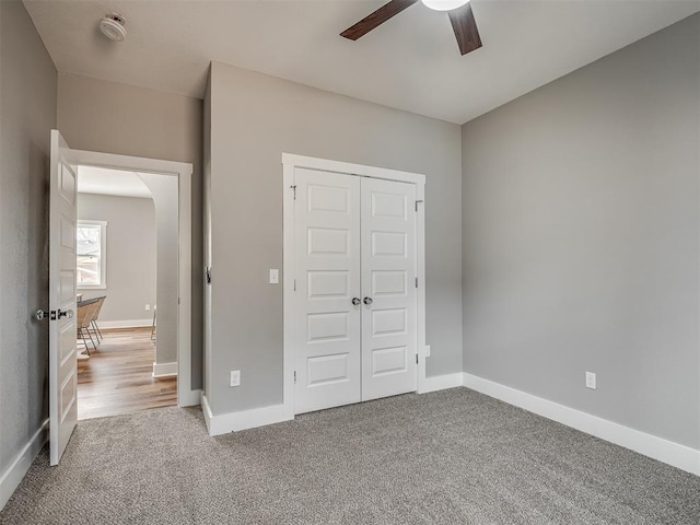 unfurnished bedroom with a ceiling fan, a closet, carpet flooring, and baseboards