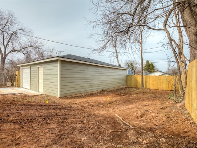 exterior space featuring a detached garage and fence