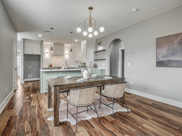 1413 NE 14th St, Oklahoma City, OK 73117 - dining space with arched walkways, dark wood finished floors, baseboards, and recessed lighting