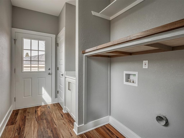 1413 NE 14th St, Oklahoma City, OK 73117 - washroom with wood finished floors, washer hookup, a textured wall, and baseboards