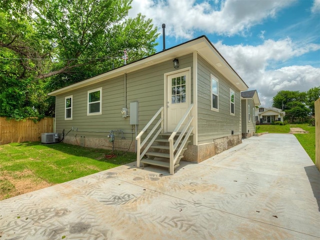1413 NE 14th St, Oklahoma City, OK 73117 - rear view of house with entry steps, driveway, central air condition unit, and a patio area