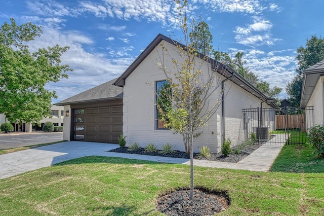 view of home's exterior featuring fence, a yard, concrete driveway, an attached garage, and brick siding