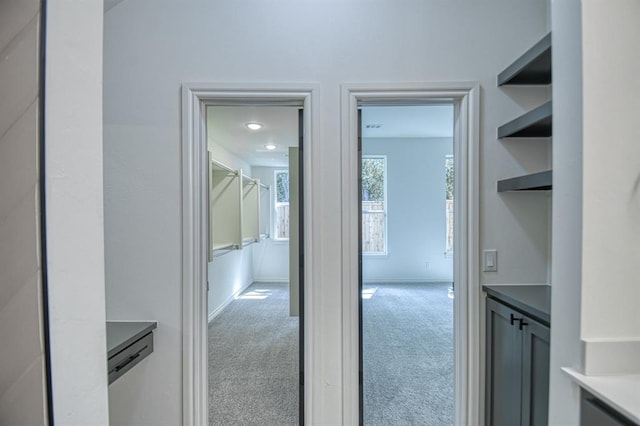 hallway featuring baseboards and carpet