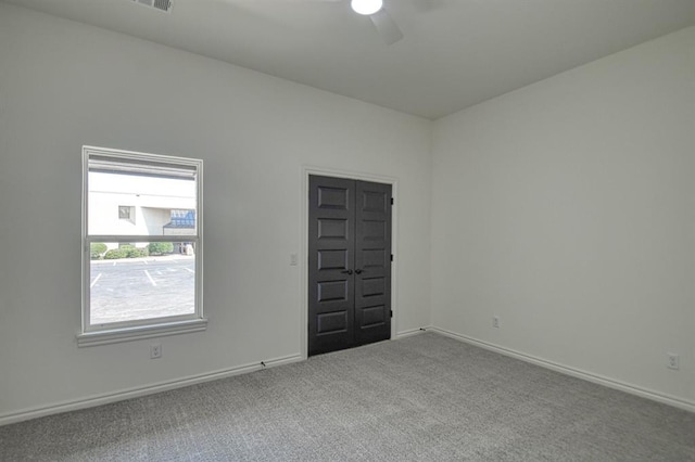 spare room with ceiling fan, baseboards, and carpet floors