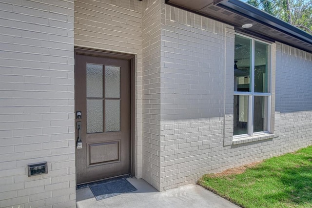 doorway to property with brick siding