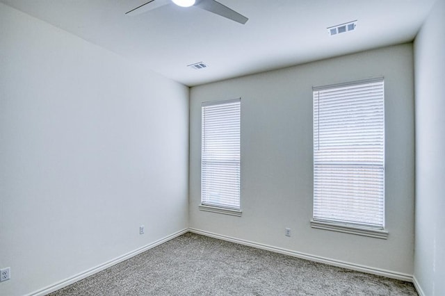 spare room featuring visible vents, baseboards, carpet flooring, and a ceiling fan