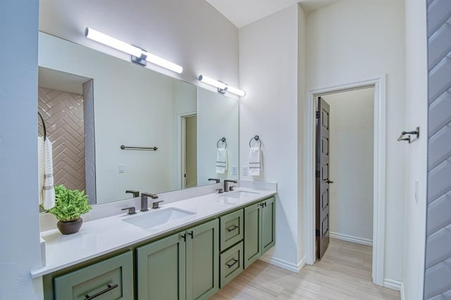 bathroom featuring a sink, baseboards, and double vanity