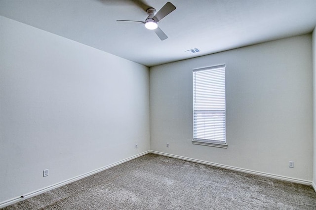 carpeted empty room with visible vents, baseboards, and ceiling fan