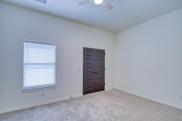 empty room with carpet flooring, baseboards, and ceiling fan