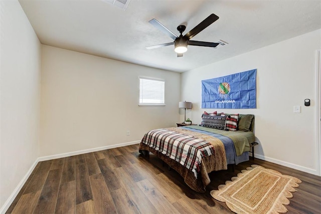 bedroom featuring visible vents, ceiling fan, baseboards, and wood finished floors