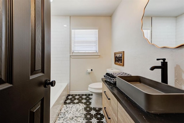 bathroom featuring vanity, toilet, and baseboards