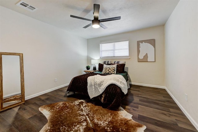 bedroom featuring baseboards, visible vents, ceiling fan, and wood finished floors