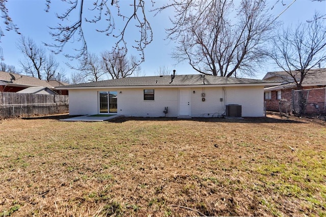 back of house with a yard, brick siding, and a fenced backyard