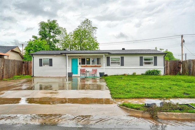 single story home with fence, covered porch, and brick siding