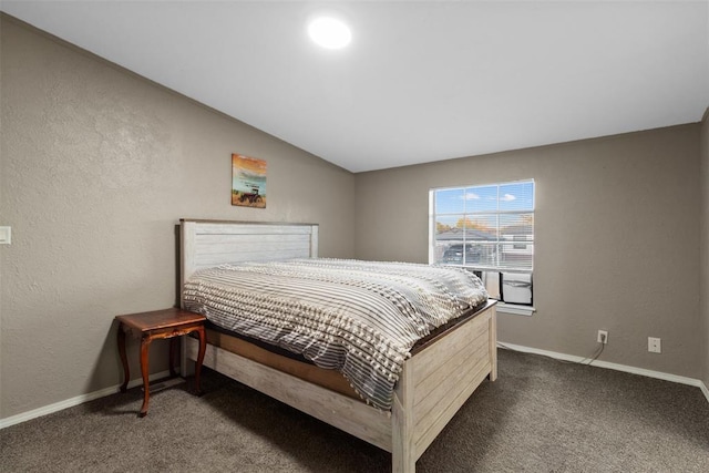 bedroom featuring lofted ceiling, dark carpet, and baseboards