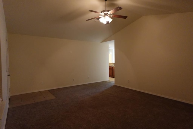 bonus room featuring a ceiling fan, dark colored carpet, vaulted ceiling, and baseboards