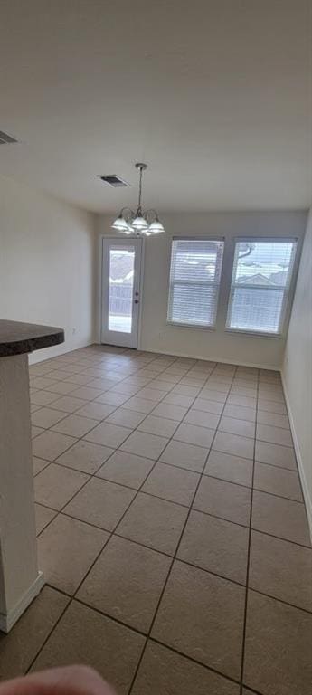 2841 NW 184th Ter, Edmond, OK 73012 - unfurnished dining area with light tile patterned flooring, visible vents, and an inviting chandelier