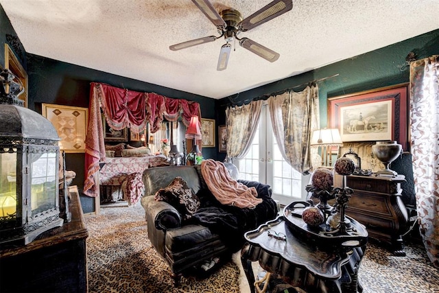 living area with a textured ceiling, a textured wall, carpet floors, a ceiling fan, and french doors