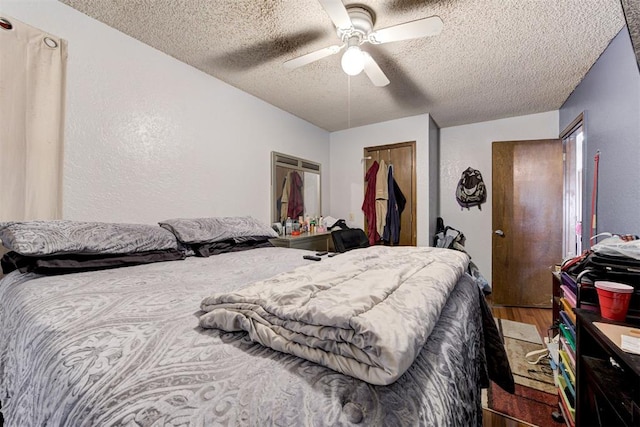 bedroom with a closet, ceiling fan, a textured ceiling, and wood finished floors