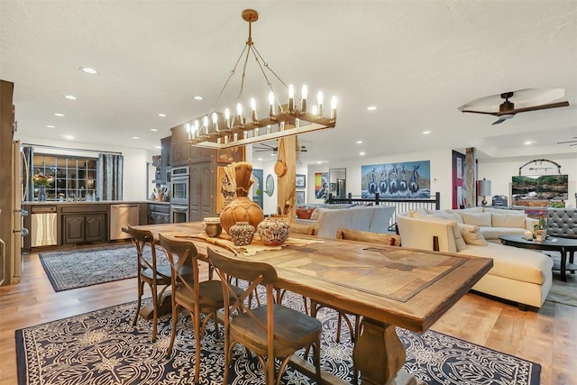 dining room with hardwood / wood-style floors and ceiling fan with notable chandelier