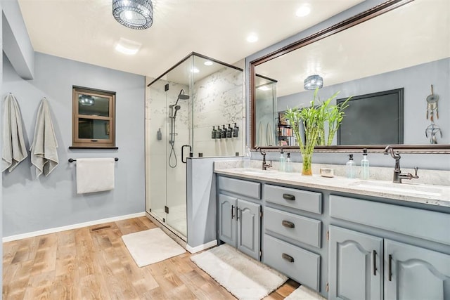 bathroom with hardwood / wood-style floors, an enclosed shower, and vanity