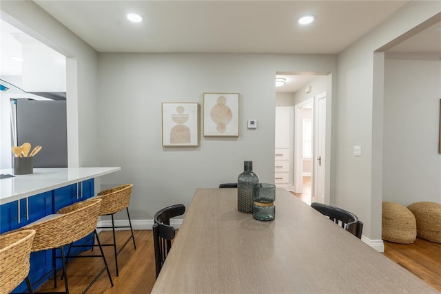 dining space featuring recessed lighting, wood finished floors, and baseboards